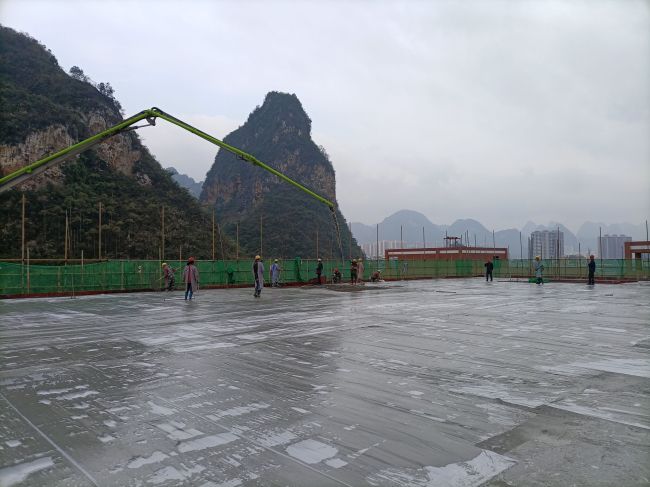 1608174054460913.jpg 风雨操场食堂屋面层混凝土浇筑现场。陈志健 摄.jpg